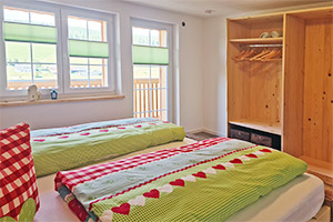 Schlafzimmer mit Doppelbett und Zugang zum Balkon